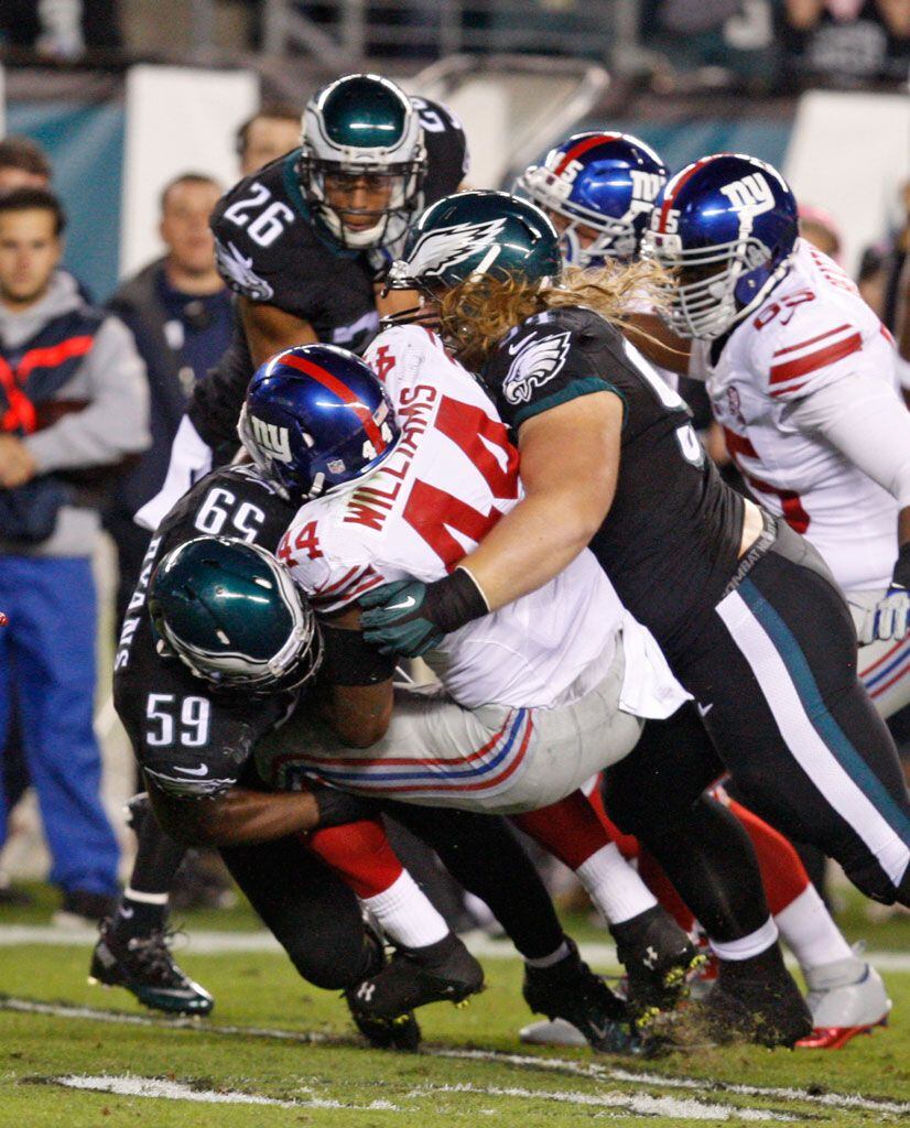 FILE - In this Sunday, Nov. 6, 2016 file photo, New York Giants quarterback  Eli Manning (10) moves out of the pocket under pressure from Philadelphia  Eagles defensive end Vinny Curry (75)