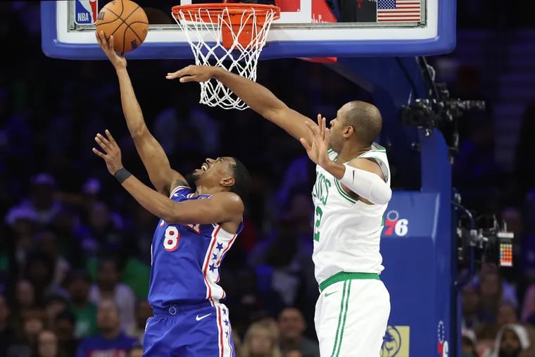 De'Anthony Melton (left) of the Sixers goes up for a reverse layup againt Al Horford of the Celtics during the second half of their game at the Wells Fargo Center on Nov. 8, 2023.