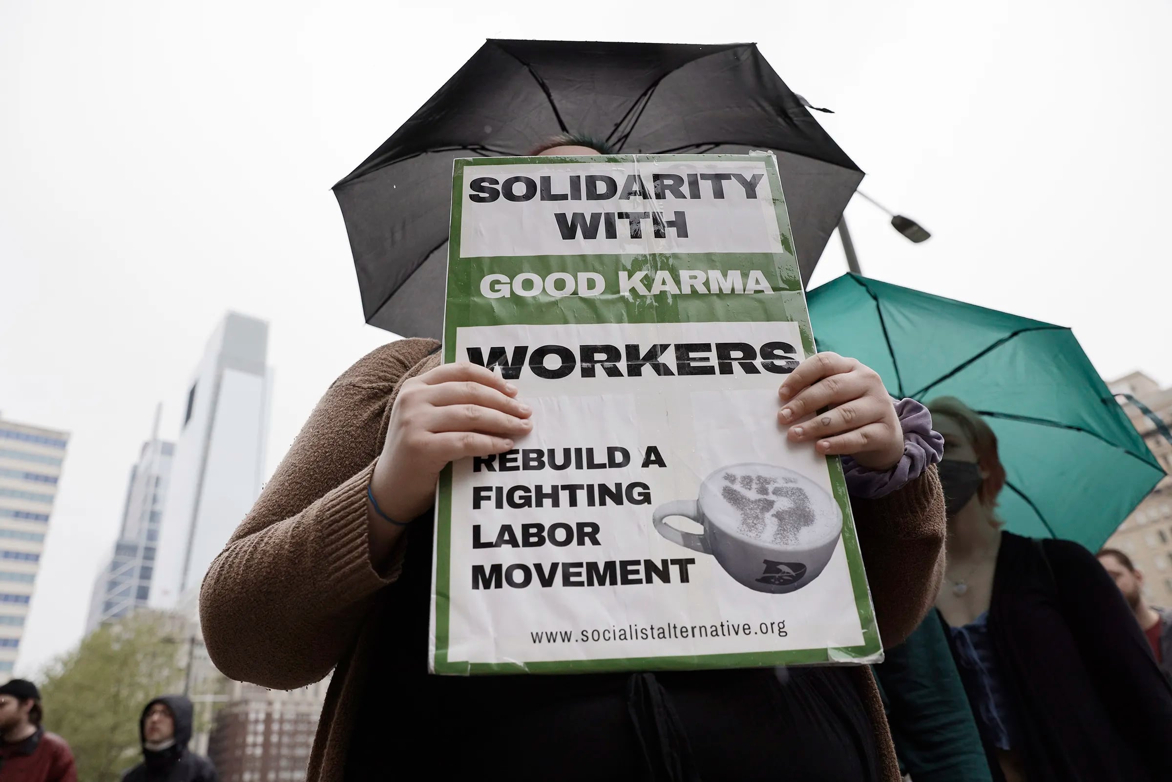 A person holds a sign supporting coffee workers at Good Karma Cafe during a rally at City Hall to support unionization among coffee workers in Philadelphia in May 2022. Less than 18 months after voting to unionize, workers voted to decertify in September.