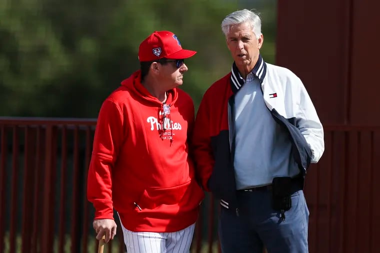 Phillies president of baseball operations Dave Dombrowski,  right, speaks with manager Rob Thomson at the BayCare Ballpark for the first day of Spring Training in Clearwater, Fla. on Wednesday, Feb. 14, 2024.