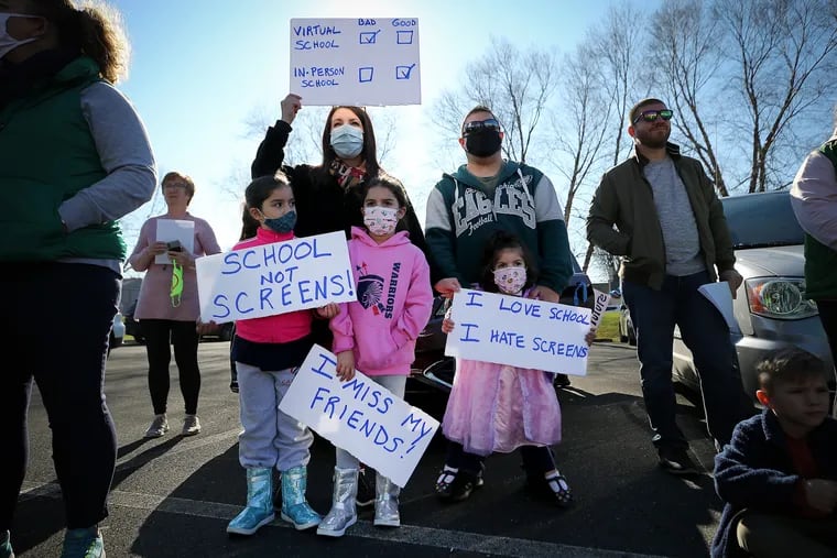 Barbara Roque (top left) holds up a sign during Sunday's rallyin Horsham. She was with her children (from left to right) Elaina, Emily and, Erica, and her husband David.