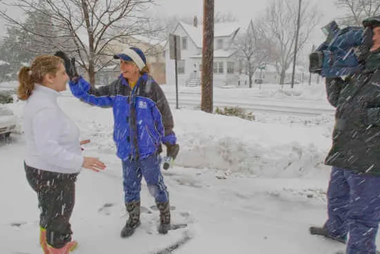 CBS3 meteorologist Carol Erickson wipes snow from the face of Stevie Logothetis, manager of the Colonial Diner on Broad Street in Woodbury, before a live report from the diner's parking lot. Cameraman Alan Wheeler captured the snowy scene Wednesday.