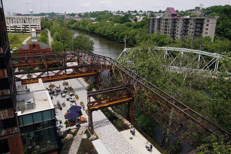 The ghostly outline of the 19th century Pencoyd Iron Works shades the new Schuylkill riverfront development in the Bala Cynwyd section of Lower Merion. The project, called Pencoyd Landing, offers spectacular views of the river, the Pencoyd Bridge, and Manayunk.