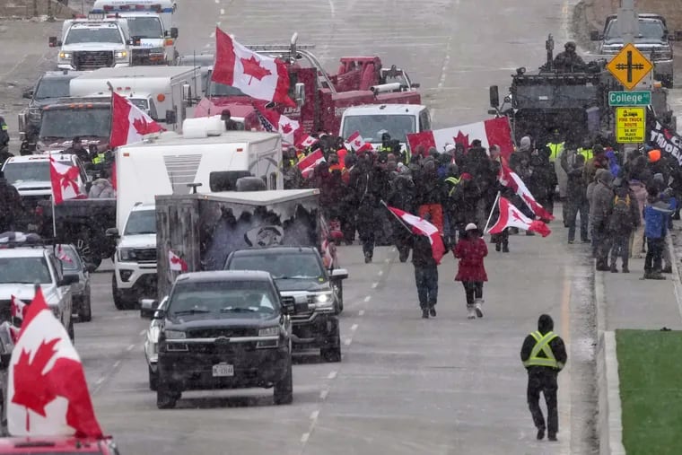 Protesters in Windsor, Ontario, face police officers Saturday as they enforce an injunction against their demonstration against COVID-19 restrictions, blocking traffic across the Ambassador Bridge.