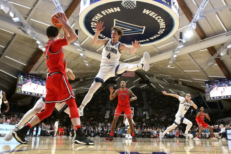 Chris Arcidiacono (center) and Villanova teammates apply a trapping defense on Brady Dunlap (left) and the St. John's offense late in Saturday's game.