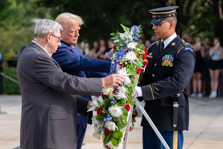 Bill Barnett, left, grandfather of Darin Taylor Hoover, and Republican presidential nominee former President Donald Trump place a wreath at the Tomb of the Unknown Solider in honor of Staff Sgt. Darin Taylor Hoover at Arlington National Cemetery on Monday, Aug. 26, 2024.