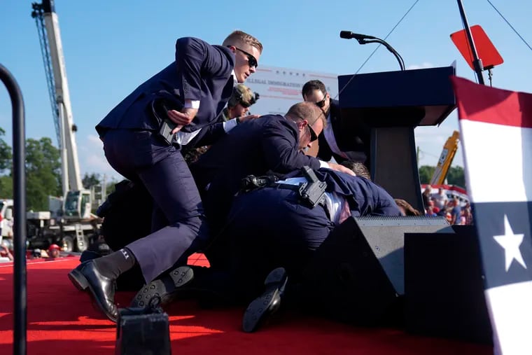 Republican presidential candidate former President Donald Trump is covered by U.S. Secret Service agents at a campaign rally, Saturday, July 13, 2024, in Butler, Pa.