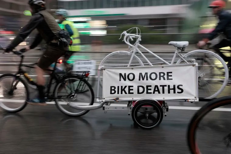 Ben Scheinfeld of Philadelphia pulls a ghost bike with NO MORE BIKE DEATHS signage during the Ride of Silence in Philadelphia on Wednesday, May 15, 2024. The ride, from City Hall to the Art Museum, honors Philadelphia cyclists killed or injured by motor vehicles.