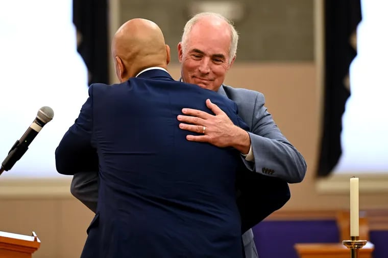 U.S. Sens. Cory Booker (left) and Bob Casey (right) embrace on the altar as they join church members and Black clergy at Prince of Peace Church in North Philadelphia Thursday as Casey campaigns for reelection against Republican challenger Dave McCormick.