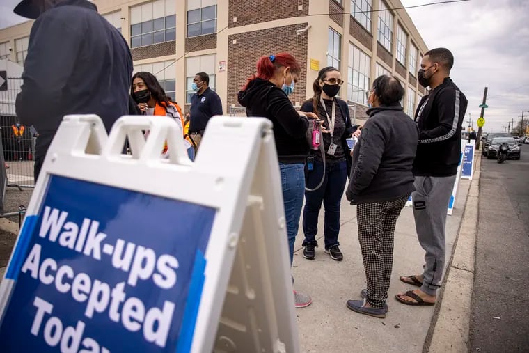 A Spanish speaking translator helps a family walking up to get their vaccination at the Esperanza Community Vaccination Center soft opening in North Philadelphia on Friday. The center will be open to the public Saturday.