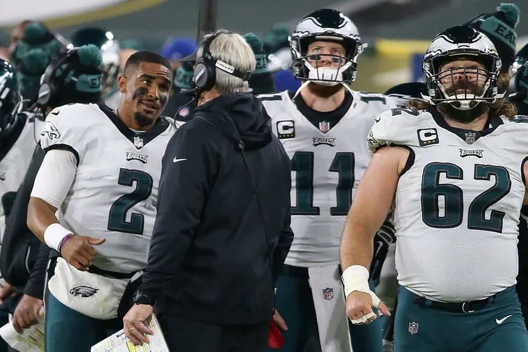 Jalen Hurts left, speaks with former coach Doug Pederson with benched starter Carson Wentz and Jason Kelce nearby during a 2020 Week 13 game in Green Bay -- the game that marked the end of Wentz's career with the Eagles.