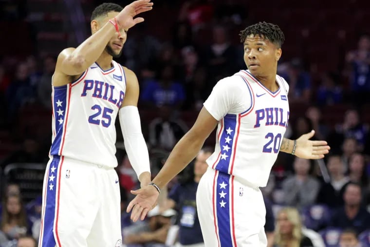Ben Simmons, left, and Markelle Fultz of the Sixers have trouble connecting on a high-five against Melbourne United in a exhibition game at the Wells Fargo Center on Sept. 28, 2018.