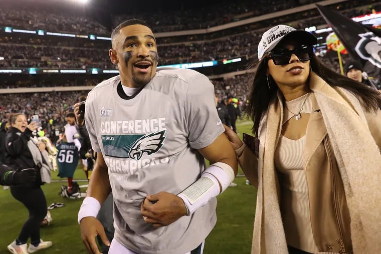 Eagles quarterback Jalen Hurts and Bryonna "Bry" Burrows stroll across the field together after the Eagles won the NFC championship in 2023.