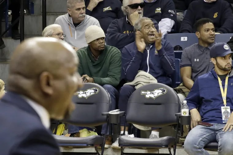 Mo Howard (right) claps for La Salle while his son, La Salle head coach Ashley Howard (in foreground on left), shouts instructions from the bench.