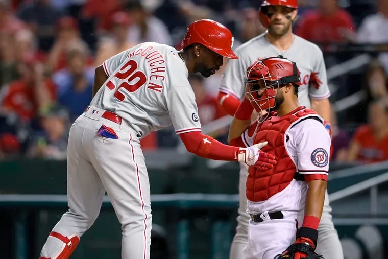 The Phillies' Andrew McCutchen taps Nationals catcher Keibert Ruiz on the chest protector as he comes home on his two-run homer during the fourth inning.