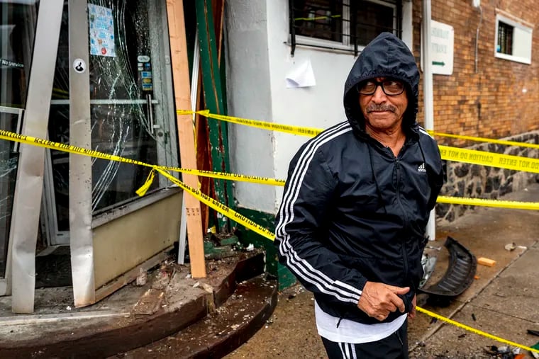 Owner Tedla Abraham outside the front door of Abyssinia Bar and Restaurant, after a car rammed the bar’s front door off its hinges.