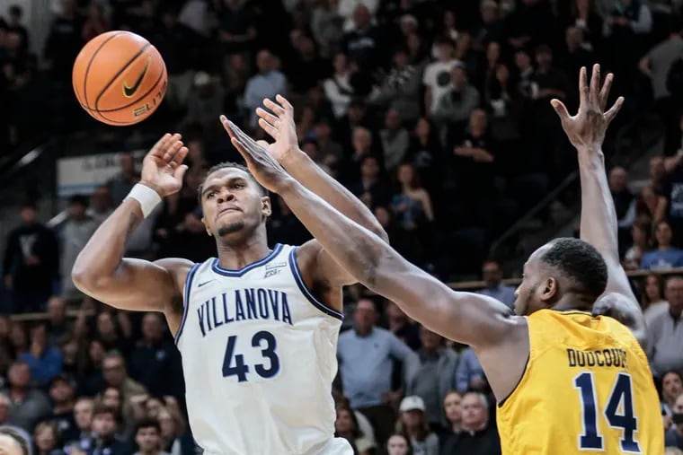 Villanova's Eric Dixon battles for a loose ball with LaSalle's Mamadou Doucoure during the first half at The Finneran Pavilion in the season opener for both teams.