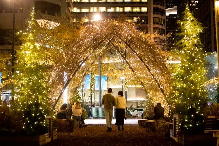 A couple walks through the Wintergarden by the Rothman Orthopedics Ice Rink at Dilworth Plaza in 2020.