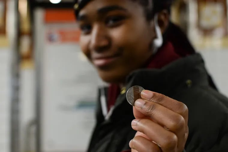 Lailani King, 16, uses tokens because the CCP upperbound program provides them to her, but she doesn't know what they'll do after tokens have been phased out. Here King holds up a token at the Spring Garden Broad Street Line subway station Dec. 22. GENEVA HEFFERNAN / Staff Photographer