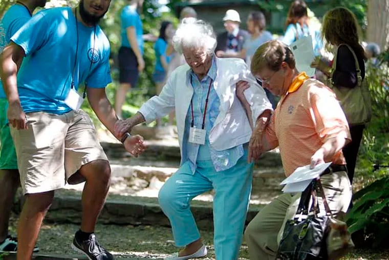 Swarthmore student Ammar Dahoowala (left) and David Williams (son of Louise)  (right)  helping Louise Williams,100, who is coming down steps to an Amphitheater. 06-07-2014 ( AKIRA SUWA  /  Staff Photographer )