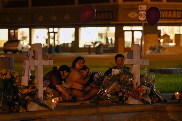 People gather at a memorial for the slain Robb Elementary School students and teachers at the City of Uvalde Town Square.