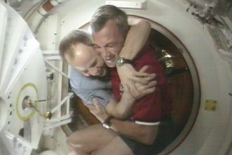 FILE - Shuttle Commander Terrence Wilcutt, right, and Mir Commander Anatoly Solovyev, left, hug after opening the hatches between the space shuttle Endeavour and the Russian Space station Mir Saturday, Jan. 24, 1998 in this image from television. Russia will opt out of the International Space Station after 2024 and focus on building its own orbiting outpost, the country's newly appointed space chief said Tuesday, July 26, 2022.