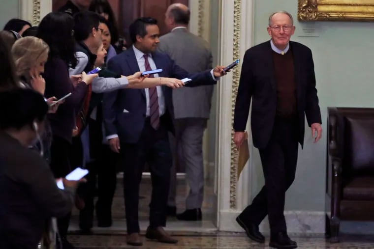 Sen. Lamar Alexander, R-Tenn., walks out of the Senate chambers during a break in President Trump's impeachment trial on Thursday.
