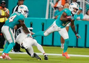 Philadelphia Eagles center Cameron Tom (66) recovers a fumble by  Philadelphia Eagles quarterback Reid Sinnett (not shown) and is tackled by Miami  Dolphins defensive tackle Niles Scott (70) and Miami Dolphins linebacker