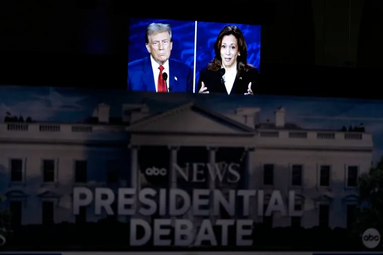 A presidential debate between Republican presidential nominee former President Donald Trump (on screen at left) and Democratic presidential nominee Vice President Kamala Harris (right) is seen from the spin room Tuesday in Philadelphia.