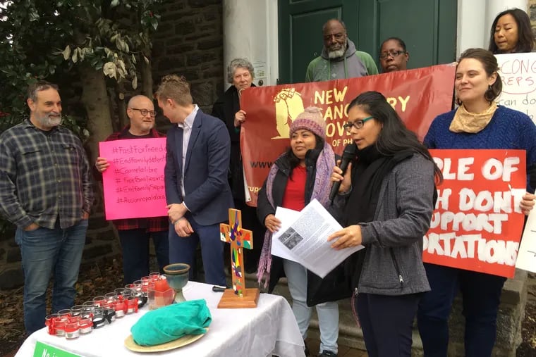 Carmela Hernandez, center, who has spent nearly two years in church sanctuary, stands at the steps of the Germantown Mennonite Church as she announces her plans for a one-day-a-week fast to rally support for her immigration case. Hernandez says she and her four children could be killed by gangsters if they are deported to Mexico. At her right, with microphone, is Blanca Pacheco. co-director of New Sanctuary Movement of Philadelphia.