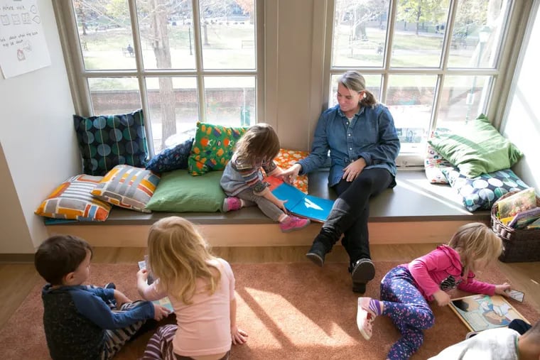 Jen Sharp, an early education program teacher, back right, reads books with students at the new  Germantown Friends School site in the Curtis Center, overlooking Washington Square.  JESSICA GRIFFIN / Staff Photographer