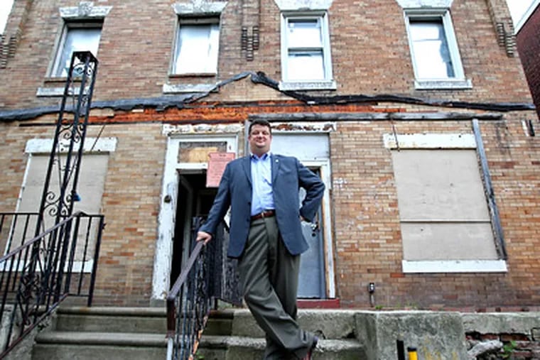 Al Perry, president of the Greater Philadelphia Association of Realtors, outside two city-owned properties he is trying to sell at 6024 and 6026 Greenway Ave. in Southwest Philadelphia. The Philadelphia Redevelopment Authority is testing his idea to help raise money. (Michael Bryant / Staff Photographer)