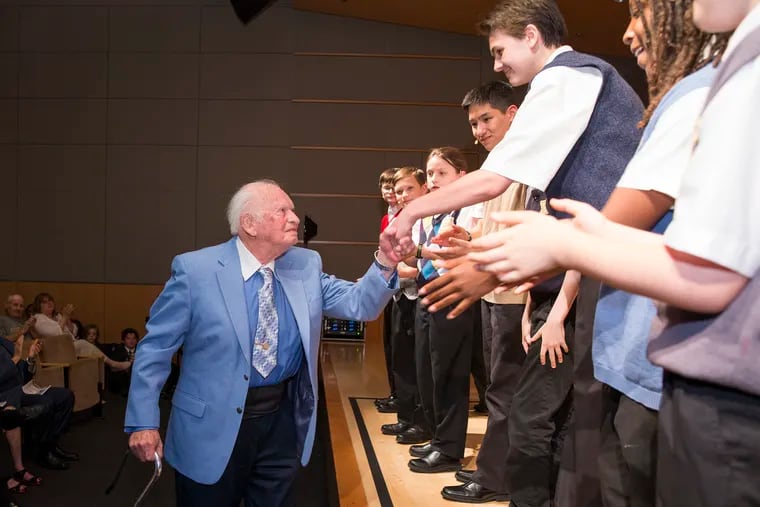 Sidney Taussig, 89, a Holocaust survivor and author, shakes hands with members of the Keystone State Boychoir following a special performance at the National Museum of American Jewish History on June 1, 2019.