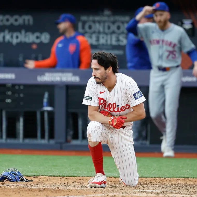 Phillies pinch runner Garrett Stubbs kneels near home plate after getting forced out in the ninth inning.