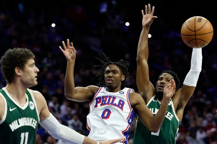 Sixers guard Tyrese Maxey passes  between Milwaukee's Brook Lopez (left) and Malik Beasley last season. The Sixers will open the season against the Bucks on Oct. 23.