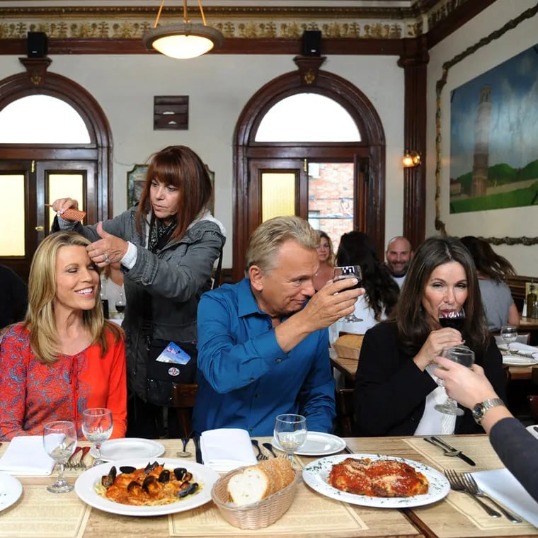 “Wheel of Fortune” co-hosts Vanna White (second from left) and Pat Sajak (to her left), seen here filming in Philadelphia at Ralph's Italian Restaurant in 2015.