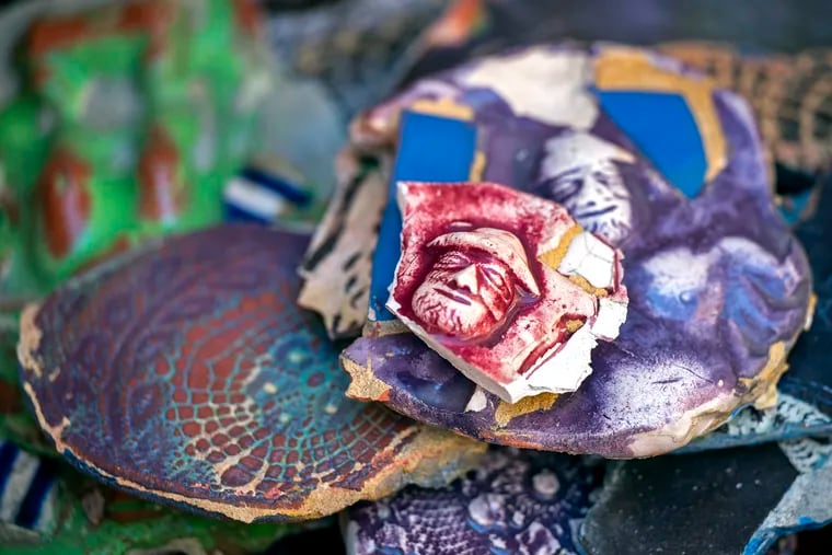 A small self-portrait of the artist on a tile is rescued as organizers and volunteers from Philadelphia's Magic Gardens save pieces of the iconic Isaiah Zagar mosaic on the exterior walls of the former Painted Bride Art Center.