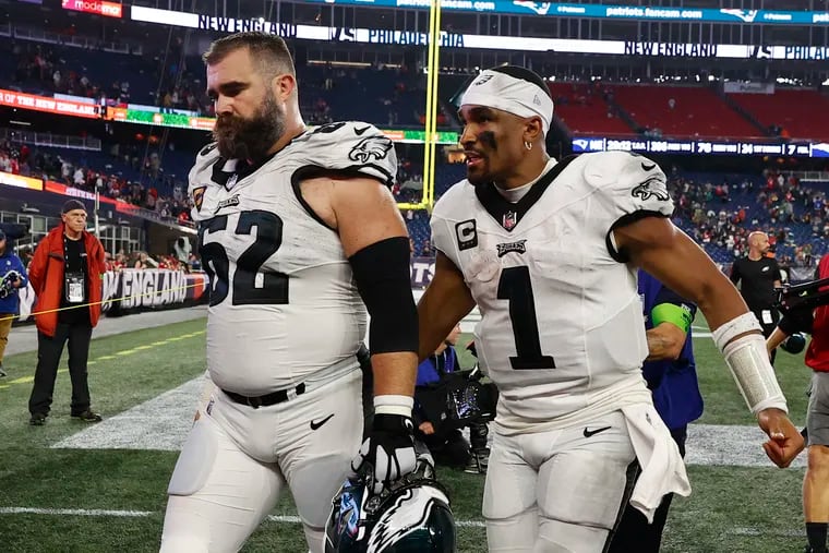 Eagles quarterback Jalen Hurts (1) and center Jason Kelce walk off the field after a win against the New England Patriots on Sept. 10, 2023.
