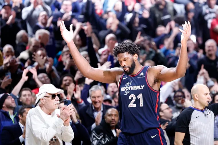 Sixers center Joel Embiid raises his arms as he leaves the game after scoring 70 points against the Spurs on Monday.