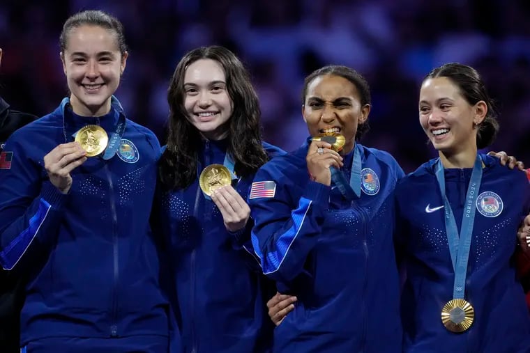 Maia Weintraub (second from left) celebrates her Olympic gold medal on the podium with Lee Kiefer, Lauren Scruggs, and Jacqueline Dubrovich on Aug. 1.