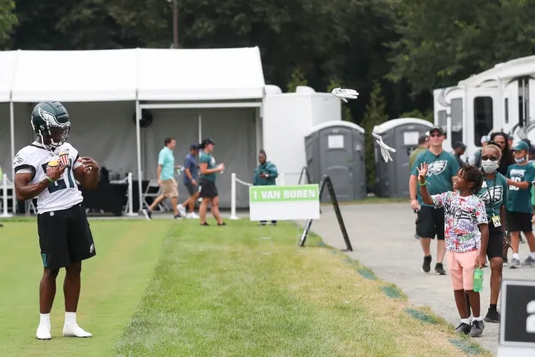 Eagles cornerback Zech McPhearson throws his gloves to fan while carrying Rita’s water ice after the second day of training camp practice.