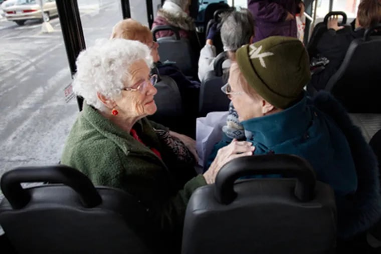 Emily Wilkinson (left) and Helene Basas greet each other as they find their seats on Abington's fixed-route bus for senior citizens. (Laurence Kesterson / Staff Photographer)