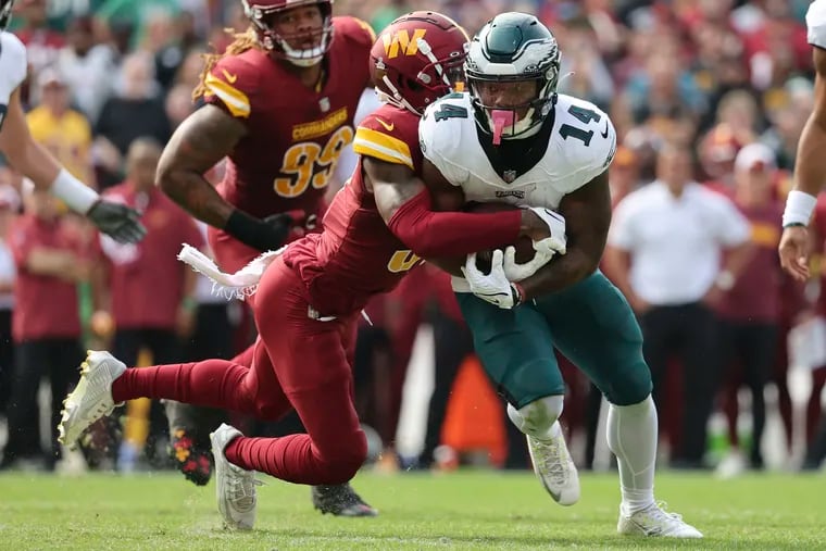 Washington Commanders safety Kamren Curl strips the ball from Eagles running back Kenneth Gainwell in the second quarter Sunday.