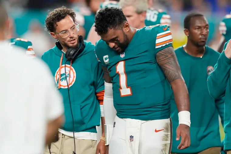 Miami Dolphins head coach Mike McDaniel talks to quarterback Tua Tagovailoa as he leaves the game after suffering a concussion Thursday night.