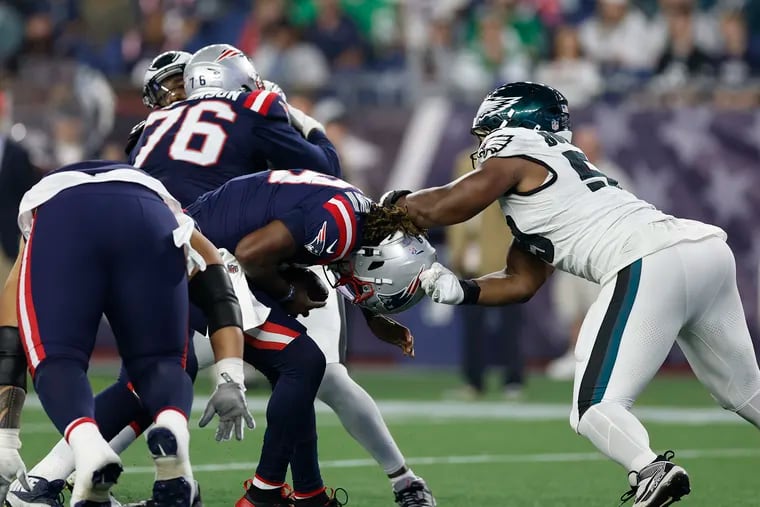 Thomas Booker (right) sacks Joe Milton III during the Eagles' preseason game against the Patriots on Aug. 15.