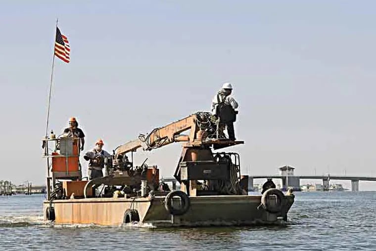 A demolition crew moves a barge into place in Barnegat Bay Thursday, May 2, 2013, in Mantoloking, N.J., to begin demolishing  a house that was swept into the bay by Superstorm Sandy last October 29. The house has been one of the defining images of the Oct. 29 storm. Mantoloking was the hardest-hit Jersey shore town. All 521 of its homes were damaged, and more than 200 were destroyed by the storm. (AP Photo/Mel Evans)