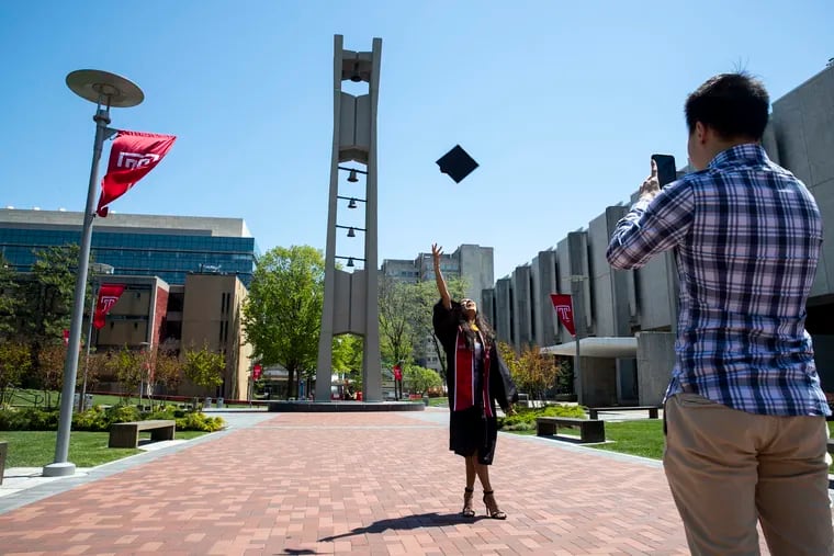 Rosemary George, 21, Class of 2020 Biology major, threw her cap as Jimmy Tan, Class of 2018, took photos at the Bell Tower on the Temple University campus in Philadelphia, Pa. on Thursday, May 7, 2020. On Thursday, Temple University held their commencement online because of coronavirus closures.