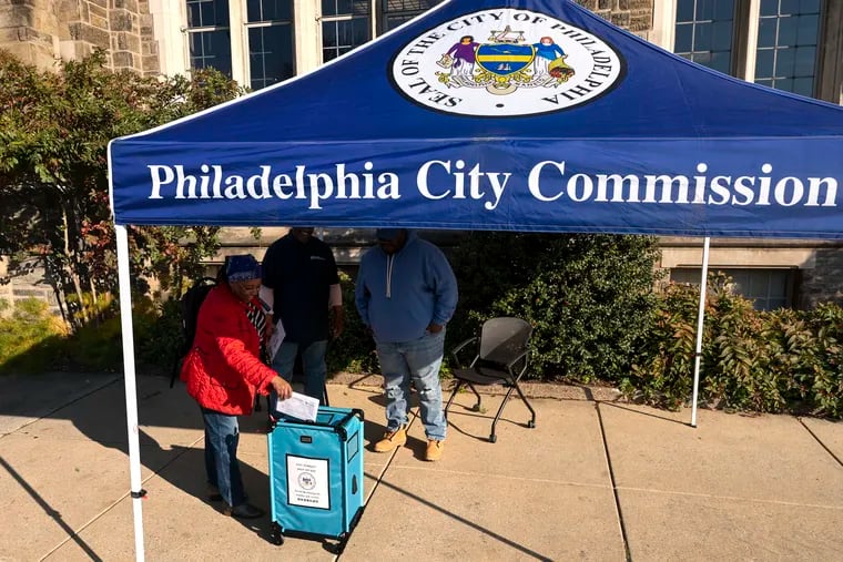 Tyea Mitchell of West Oak Lane deposits her mail-in ballot in a box at the temporary drop-off site on the Temple University campus on North Broad Street in November.