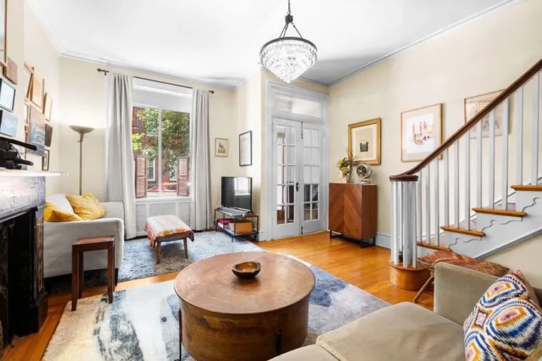 The living room of Bernice and Paul Kelly's Fairmount home features bordered hardwood floors, a decorative mantle, and an oversize front window.