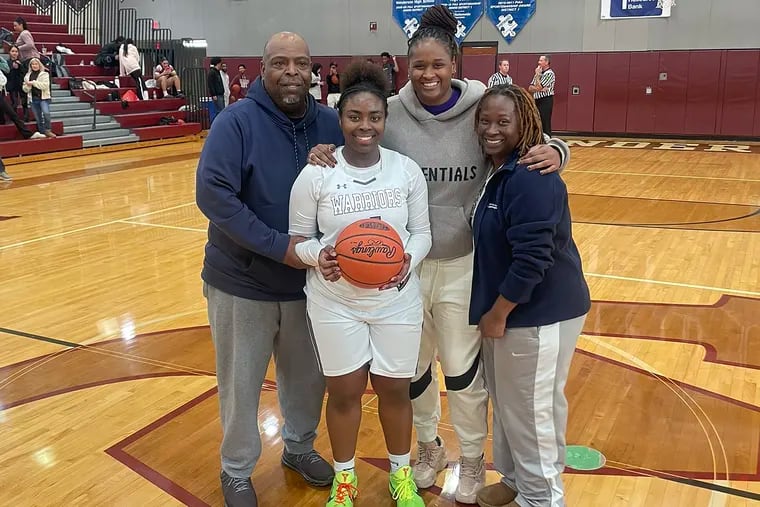 Whitney Evans (second from left) poses with her sister Shante (second from right) and her parents after scoring her 1,000th career point earlier this season.